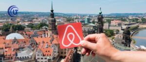 Persona con logo en la mano de Airbnb - El fenómeno Airbnb y las regulaciones en Bogotá