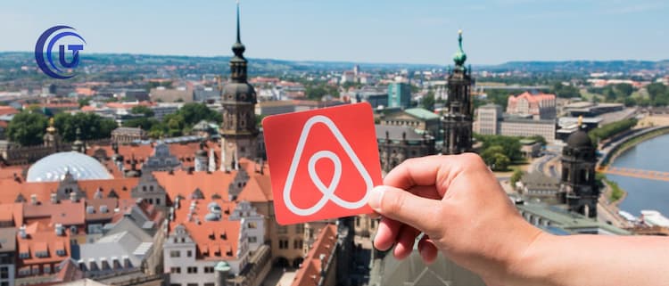 Persona con logo en la mano de Airbnb - El fenómeno Airbnb y las regulaciones en Bogotá