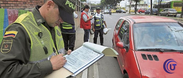 Policía colocando comperendo por placa en Colombia.